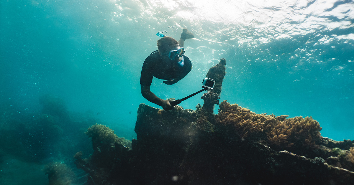 Duiker met een GoPro, die duikt naar een scheepswrak